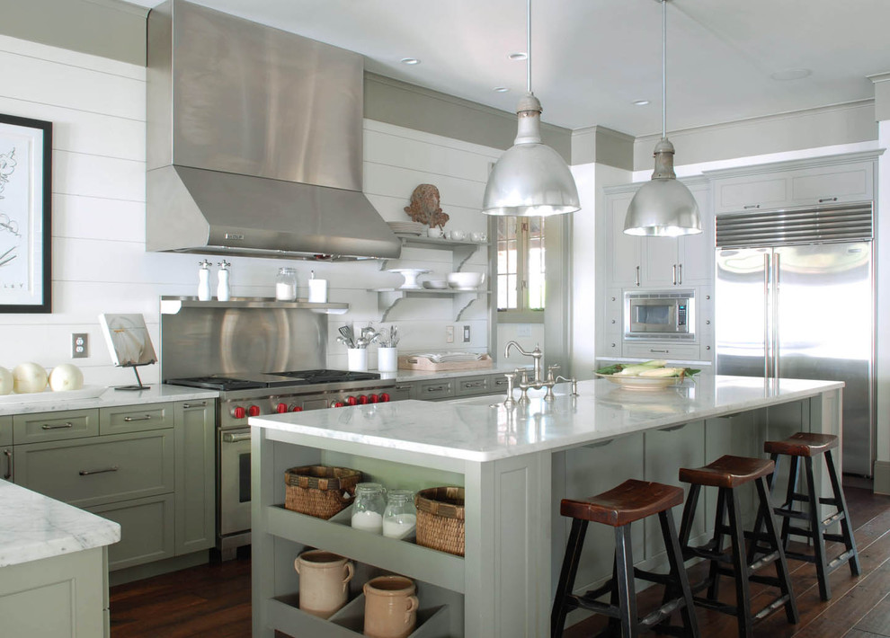 Klassisk inredning av ett kök, med rostfria vitvaror, en rustik diskho, luckor med infälld panel, marmorbänkskiva och gröna skåp