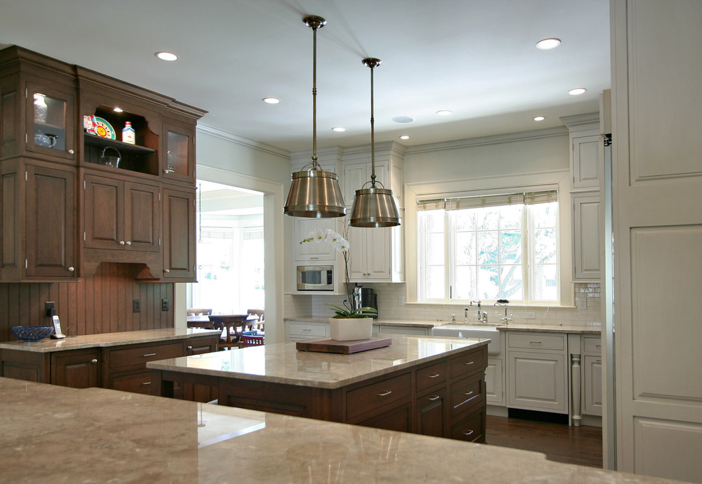 Traditional kitchen in Atlanta with raised-panel cabinets, dark wood cabinets, white splashback and metro tiled splashback.
