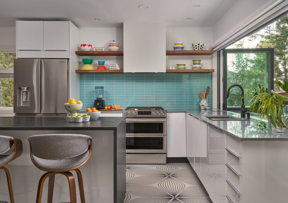 Moderne Wohnküche in L-Form mit Doppelwaschbecken, flächenbündigen Schrankfronten, weißen Schränken, Küchenrückwand in Blau, Rückwand aus Glasfliesen, Küchengeräten aus Edelstahl, Kücheninsel, buntem Boden und grauer Arbeitsplatte in Minneapolis
