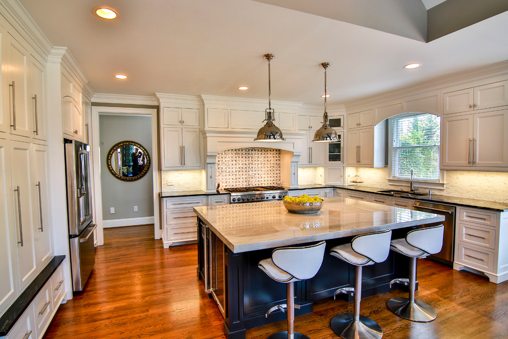 Example of a large transitional u-shaped medium tone wood floor eat-in kitchen design in Other with a double-bowl sink, beaded inset cabinets, white cabinets, quartzite countertops, white backsplash, mosaic tile backsplash, stainless steel appliances and an island