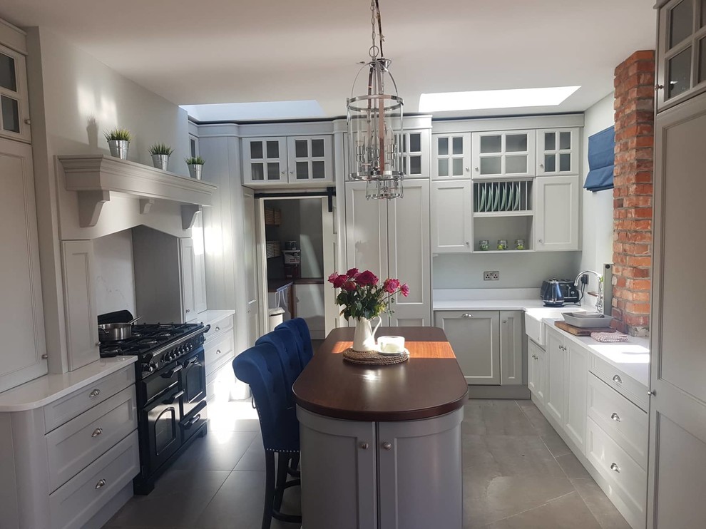 This is an example of a medium sized country u-shaped open plan kitchen in Other with a belfast sink, shaker cabinets, grey cabinets, granite worktops, white splashback, stone slab splashback, integrated appliances, porcelain flooring, an island, grey floors and white worktops.