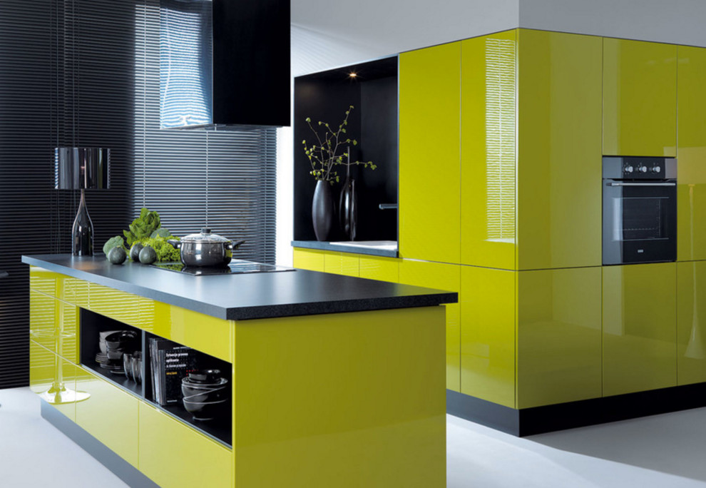 Large modern single-wall kitchen/diner in New York with a built-in sink, flat-panel cabinets, yellow cabinets, soapstone worktops, black appliances, concrete flooring, an island and grey floors.