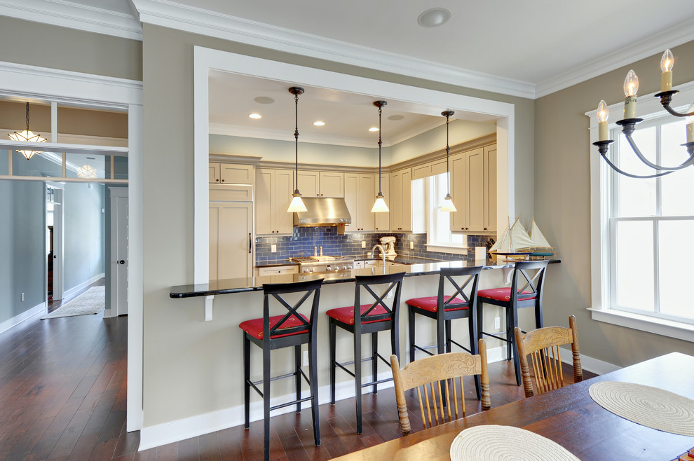 Inspiration for a timeless u-shaped kitchen remodel in Philadelphia with granite countertops, blue backsplash, subway tile backsplash, shaker cabinets, beige cabinets and paneled appliances