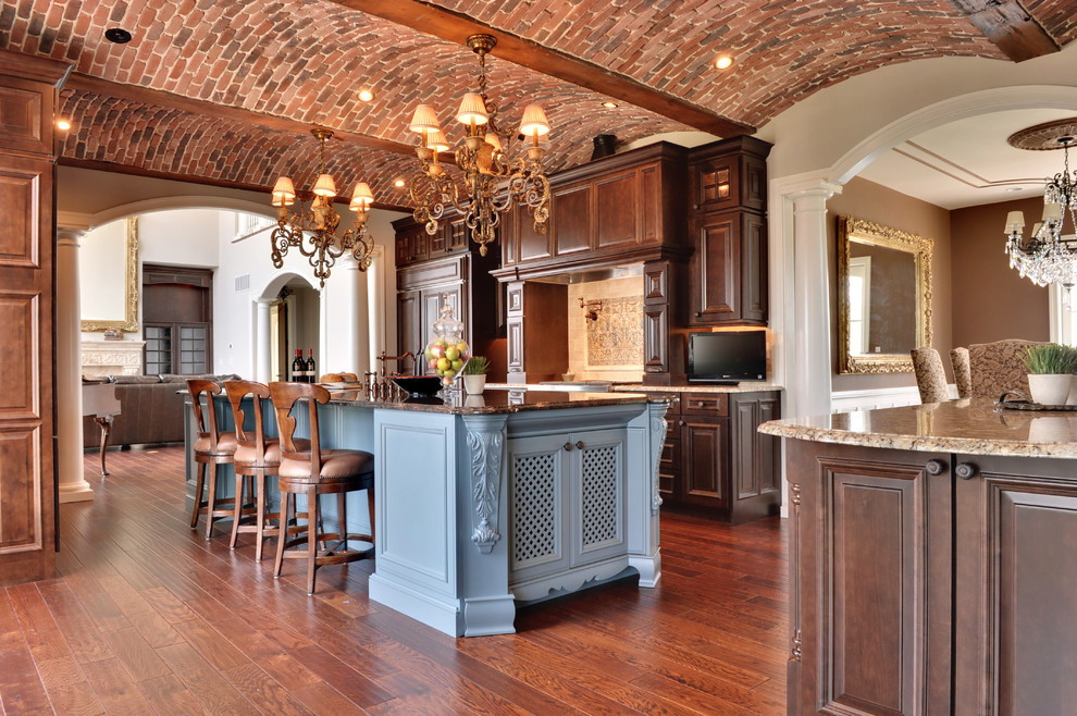 Kitchen - mediterranean galley kitchen idea in Philadelphia with raised-panel cabinets, dark wood cabinets and paneled appliances