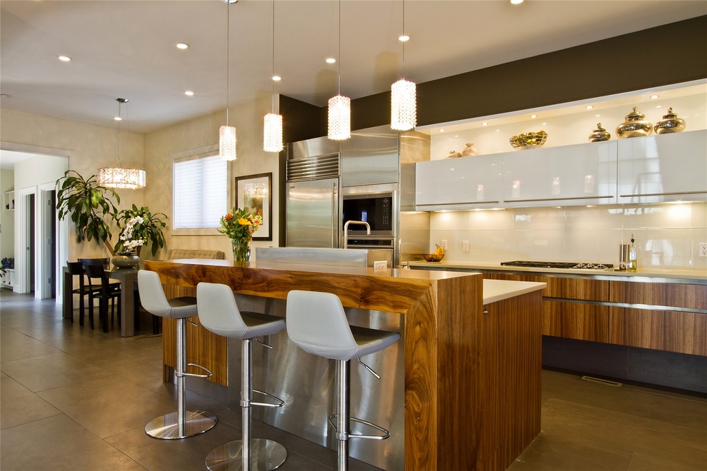 Example of a trendy kitchen design in Denver with flat-panel cabinets and stainless steel appliances
