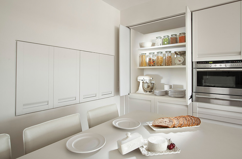 Moderne Küchenbar mit Schrankfronten im Shaker-Stil, weißen Schränken und Küchengeräten aus Edelstahl in Sonstige