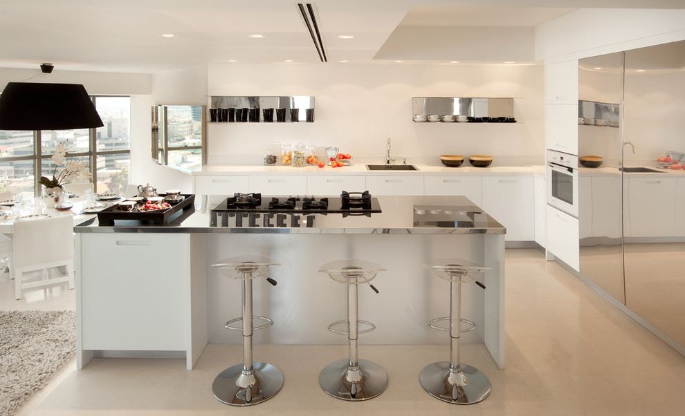 Moderne Wohnküche mit Küchengeräten aus Edelstahl, Edelstahl-Arbeitsplatte, Einbauwaschbecken und flächenbündigen Schrankfronten in Sonstige