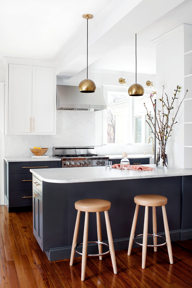 Transitional medium tone wood floor kitchen photo in Baltimore with shaker cabinets, marble countertops, stone slab backsplash, stainless steel appliances and a peninsula