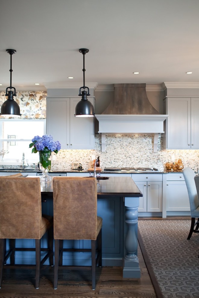 Cette photo montre une cuisine américaine bicolore chic avec un placard à porte shaker, des portes de placard grises, une crédence multicolore et une crédence en mosaïque.