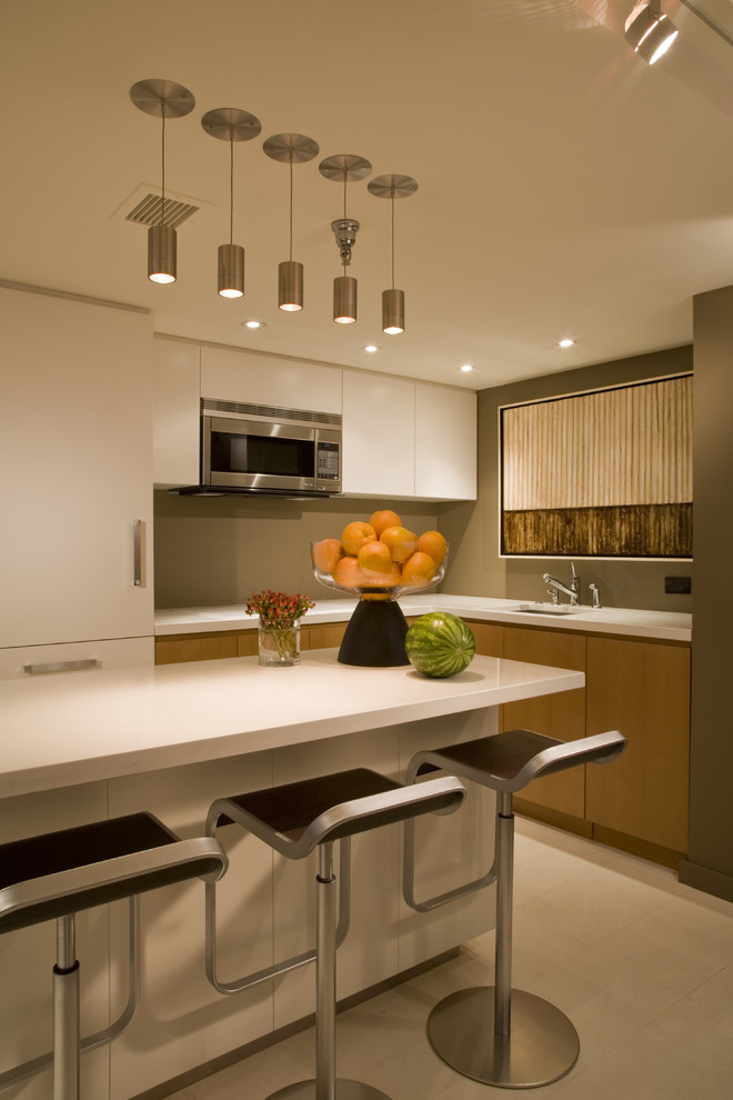 Photo of a small contemporary l-shaped open plan kitchen in DC Metro with a submerged sink, flat-panel cabinets, medium wood cabinets, engineered stone countertops, integrated appliances, limestone flooring and beige floors.