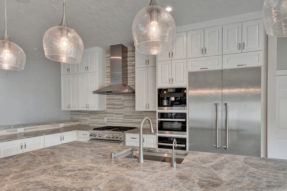 Large transitional l-shaped medium tone wood floor and brown floor eat-in kitchen photo in Austin with a double-bowl sink, raised-panel cabinets, white cabinets, quartzite countertops, stainless steel appliances, an island, gray backsplash, mosaic tile backsplash and gray countertops
