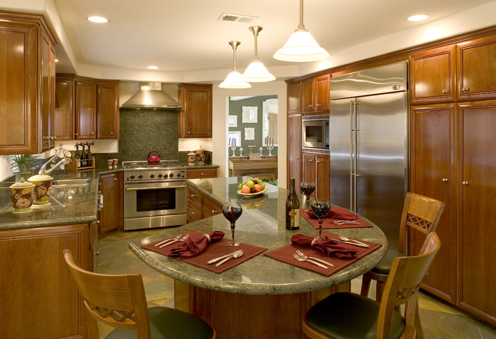 Exempel på ett avskilt klassiskt grön grönt kök, med rostfria vitvaror, en undermonterad diskho, luckor med upphöjd panel, skåp i mellenmörkt trä, granitbänkskiva, grönt stänkskydd, stänkskydd i sten, klinkergolv i terrakotta, en köksö och flerfärgat golv