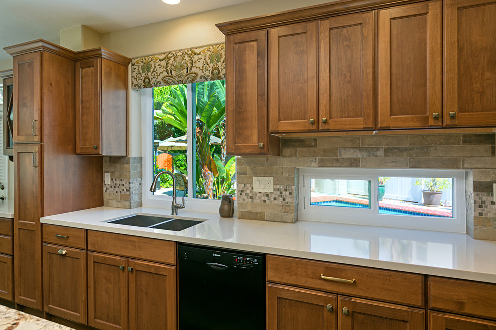 Foto på ett mellanstort vintage flerfärgad kök, med en undermonterad diskho, luckor med infälld panel, skåp i mellenmörkt trä, granitbänkskiva, flerfärgad stänkskydd, stänkskydd i keramik, rostfria vitvaror och en köksö