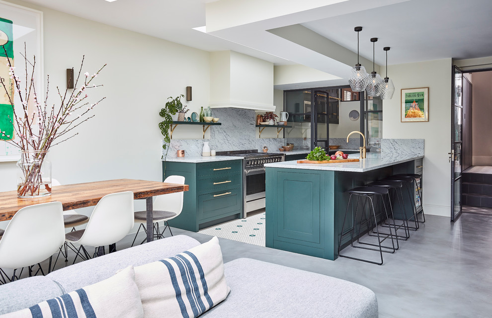 Design ideas for a classic galley open plan kitchen in London with a submerged sink, shaker cabinets, green cabinets, grey splashback, stainless steel appliances, a breakfast bar, white floors and grey worktops.