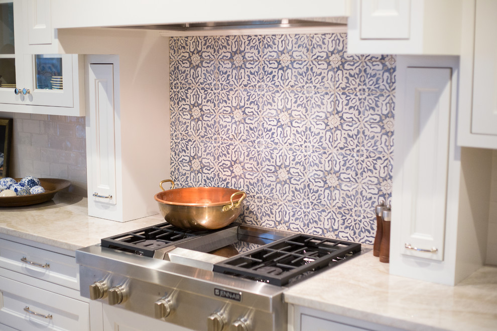 Klassisk inredning av ett mellanstort kök, med en enkel diskho, luckor med infälld panel, vita skåp, träbänkskiva, blått stänkskydd, stänkskydd i terrakottakakel, integrerade vitvaror, travertin golv och en köksö