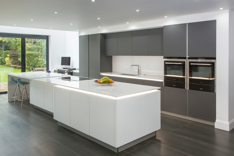 Große Moderne Küche in grau-weiß mit flächenbündigen Schrankfronten, grauen Schränken, Quarzit-Arbeitsplatte, Küchenrückwand in Weiß, Kücheninsel und Unterbauwaschbecken in Essex