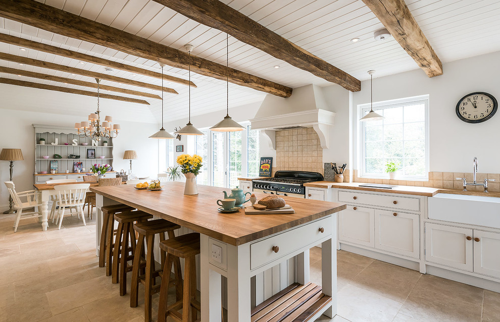 Large farmhouse ceramic tile eat-in kitchen photo in London with a farmhouse sink, beaded inset cabinets, white cabinets, beige backsplash, ceramic backsplash and an island