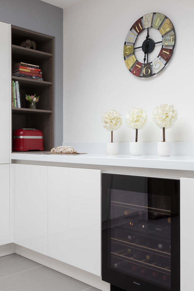 Foto di una cucina minimal di medie dimensioni con ante lisce, ante bianche, elettrodomestici neri, pavimento con piastrelle in ceramica e pavimento grigio