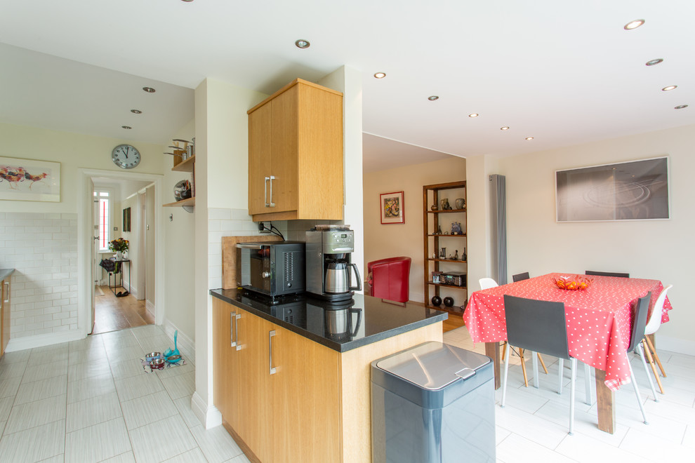 Medium sized contemporary galley kitchen/diner in Other with flat-panel cabinets, medium wood cabinets, granite worktops, ceramic flooring and a breakfast bar.
