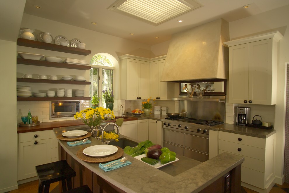 Exempel på ett stort modernt kök, med rostfria vitvaror, vita skåp, bänkskiva i kalksten, vitt stänkskydd, en undermonterad diskho, luckor med infälld panel, stänkskydd i keramik, korkgolv, en köksö och brunt golv