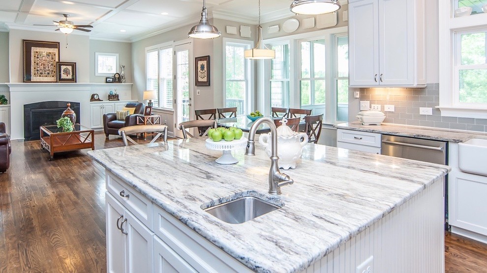 Eat-in kitchen - mid-sized country dark wood floor and brown floor eat-in kitchen idea in Raleigh with a farmhouse sink, shaker cabinets, white cabinets, quartzite countertops, gray backsplash, subway tile backsplash, stainless steel appliances and an island