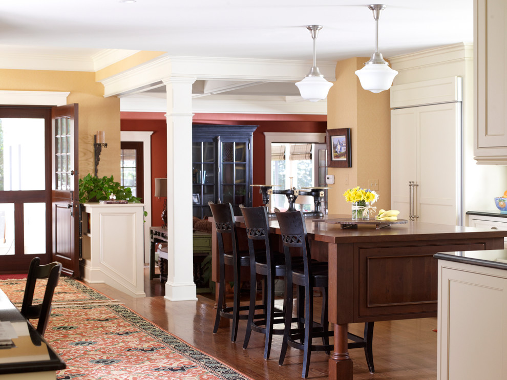 На фото: угловая кухня-гостиная в классическом стиле с фасадами с декоративным кантом, белыми фасадами и гранитной столешницей