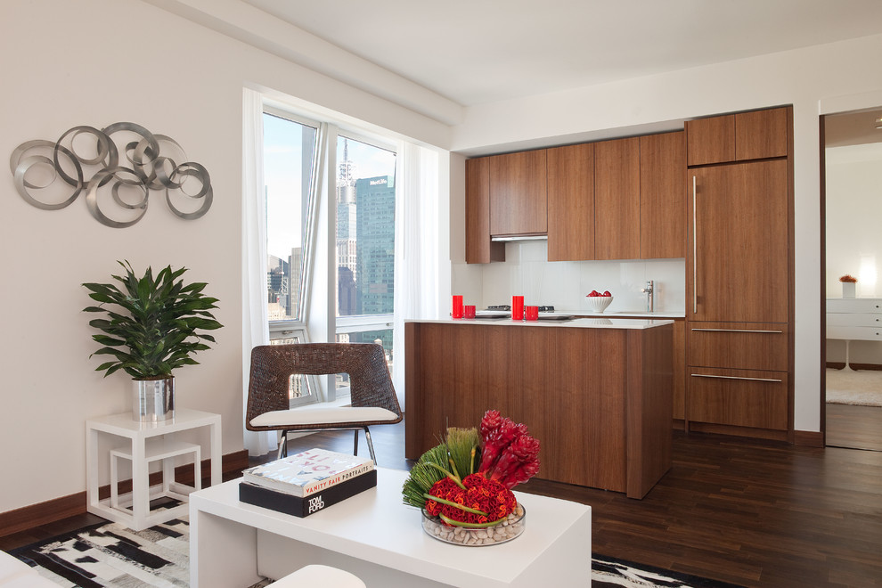 Zweizeilige, Kleine Moderne Wohnküche mit flächenbündigen Schrankfronten, hellbraunen Holzschränken, Küchenrückwand in Weiß, Glasrückwand und dunklem Holzboden in Miami