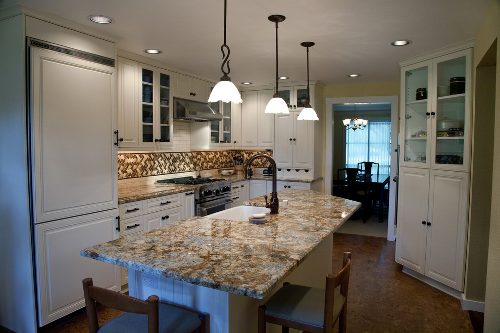 Inredning av ett klassiskt stort kök, med en rustik diskho, luckor med upphöjd panel, vita skåp, granitbänkskiva, flerfärgad stänkskydd, stänkskydd i mosaik, integrerade vitvaror, en köksö och betonggolv
