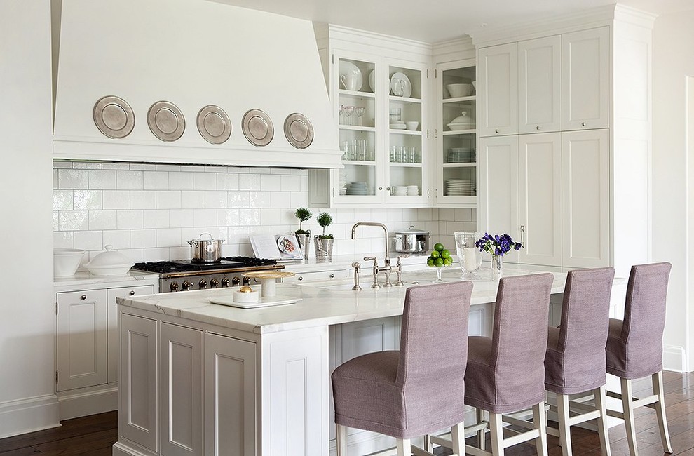 This is an example of a traditional l-shaped kitchen in Phoenix with a submerged sink, shaker cabinets, white cabinets, white splashback, dark hardwood flooring and an island.