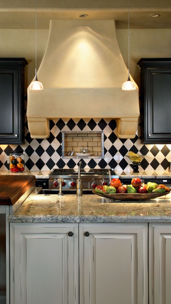 Inspiration for a mediterranean u-shaped ceramic tile open concept kitchen remodel in Phoenix with an undermount sink, beaded inset cabinets, black cabinets, marble countertops, multicolored backsplash, ceramic backsplash, stainless steel appliances and an island