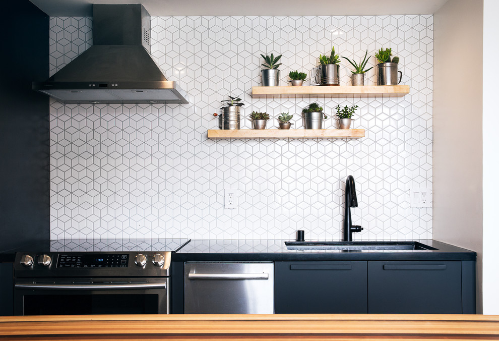 Inspiration for a small contemporary galley concrete floor and gray floor kitchen remodel in San Francisco with an undermount sink, flat-panel cabinets, quartzite countertops, white backsplash, ceramic backsplash, stainless steel appliances and black countertops