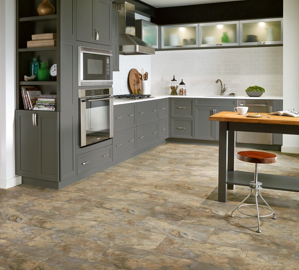 Example of a mid-sized classic l-shaped vinyl floor kitchen design in Boston with shaker cabinets, gray cabinets, solid surface countertops, white backsplash, glass tile backsplash, stainless steel appliances and an island