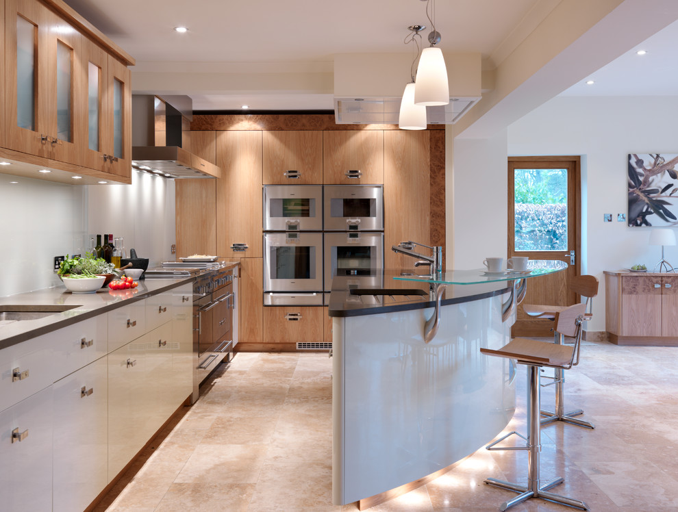 Exempel på ett stort modernt kök, med en nedsänkt diskho, släta luckor, bänkskiva i kvartsit, vitt stänkskydd, rostfria vitvaror, travertin golv och en halv köksö