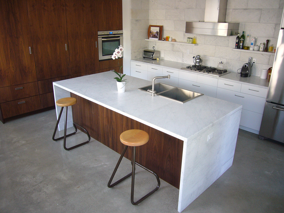 Immagine di una cucina design con top in marmo e elettrodomestici in acciaio inossidabile