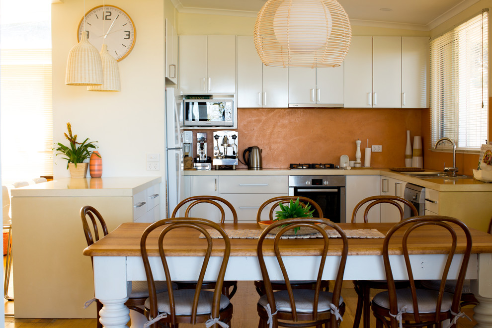 Offene, Mittelgroße Moderne Küche in L-Form mit weißen Schränken, Betonarbeitsplatte, Küchenrückwand in Rosa, Halbinsel und beiger Arbeitsplatte in Geelong