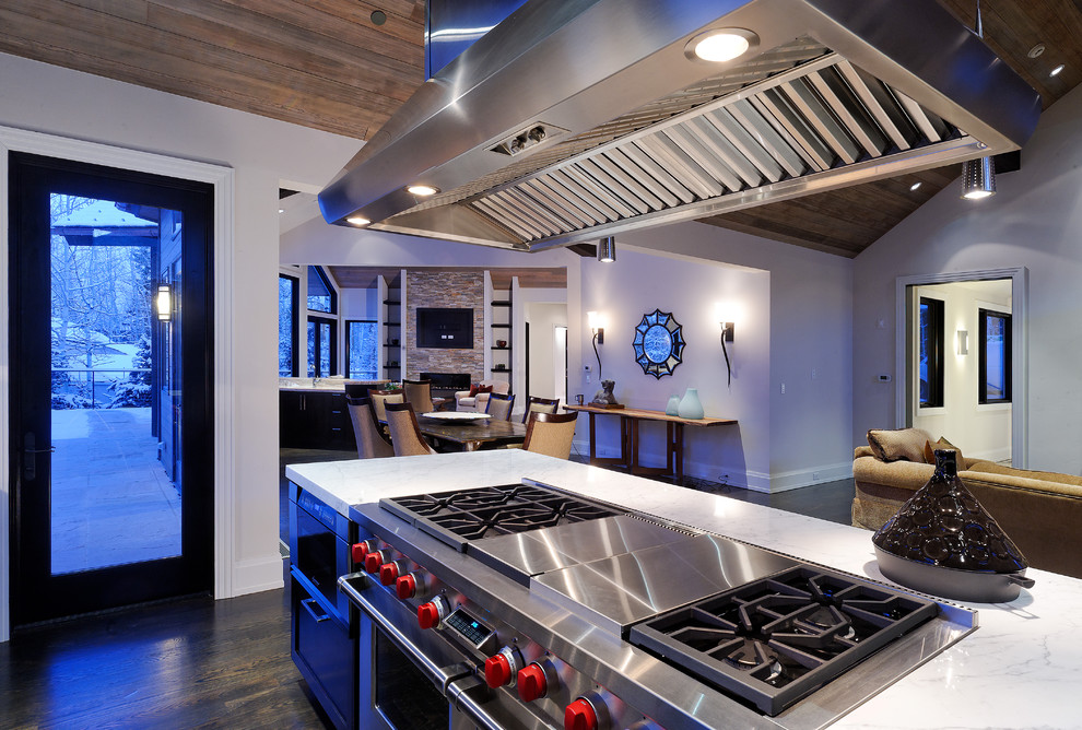 This is an example of a rustic open plan kitchen in Denver with stainless steel appliances.