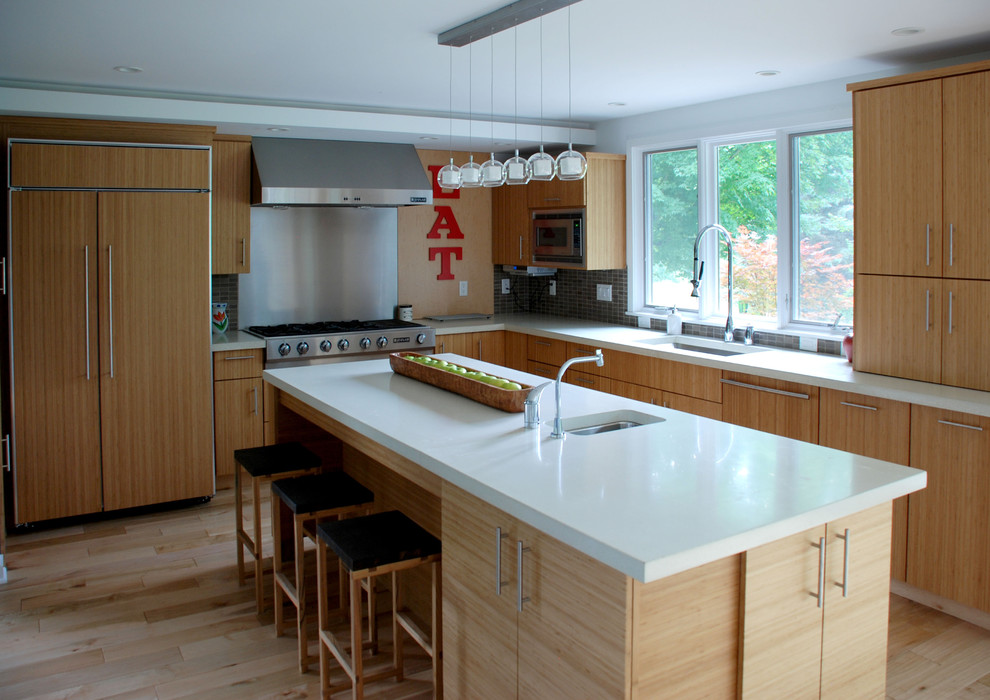 Example of a trendy kitchen design in Detroit with paneled appliances and concrete countertops