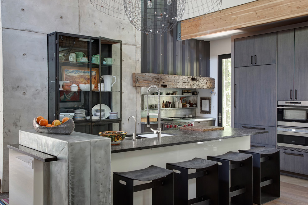 Moderne Küche mit Unterbauwaschbecken, flächenbündigen Schrankfronten, Küchengeräten aus Edelstahl, Kücheninsel und grauen Schränken in Chicago