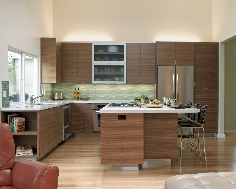 サンフランシスコにあるコンテンポラリースタイルのおしゃれなキッチン (フラットパネル扉のキャビネット、濃色木目調キャビネット、緑のキッチンパネル、シルバーの調理設備) の写真