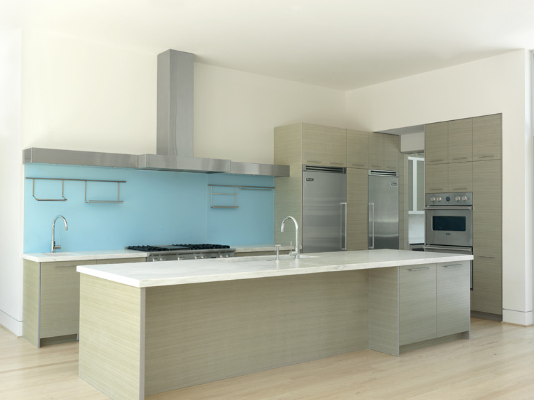 Ejemplo de cocina actual con fregadero bajoencimera, armarios con paneles lisos, puertas de armario grises y electrodomésticos de acero inoxidable