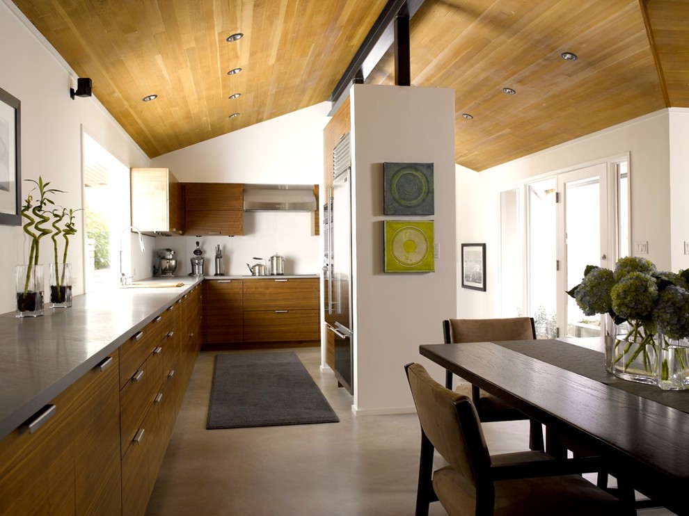 Mid-sized trendy l-shaped concrete floor and gray floor eat-in kitchen photo in Seattle with stainless steel appliances, an undermount sink, flat-panel cabinets, medium tone wood cabinets, concrete countertops, no island and gray countertops