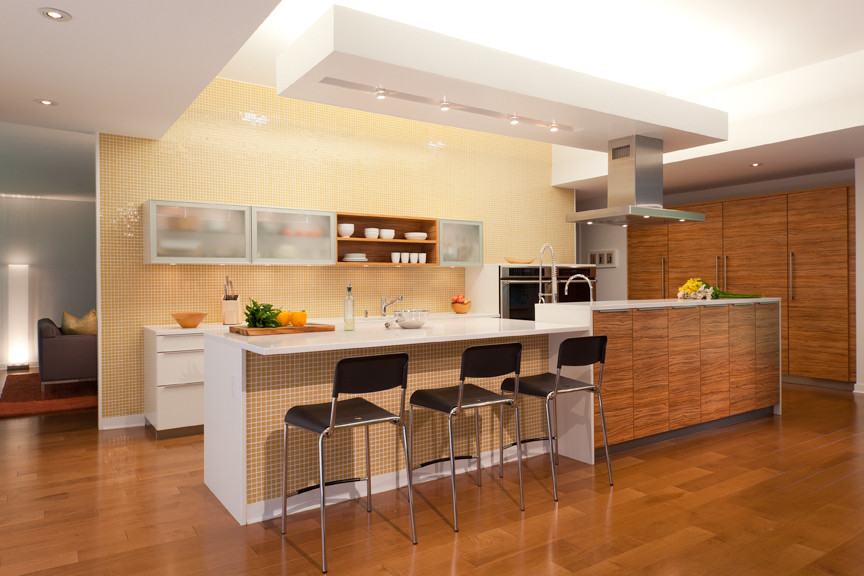 Idee per una cucina moderna con top in quarzo composito, paraspruzzi giallo, paraspruzzi con piastrelle di vetro e pavimento in legno massello medio