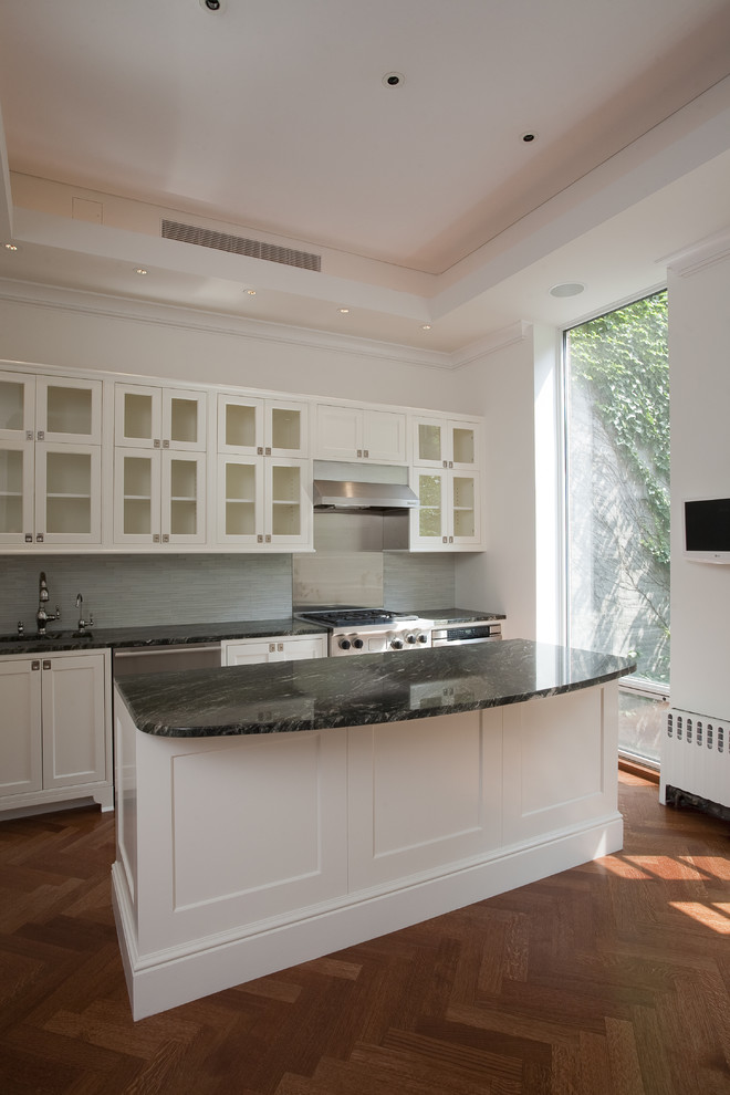 This is an example of a medium sized classic single-wall kitchen in New York with shaker cabinets, white cabinets, blue splashback, stainless steel appliances, dark hardwood flooring and an island.