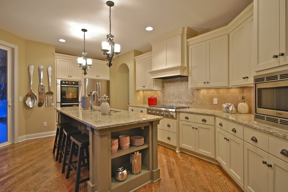 Cette image montre une cuisine traditionnelle avec un électroménager en acier inoxydable et un plan de travail en granite.