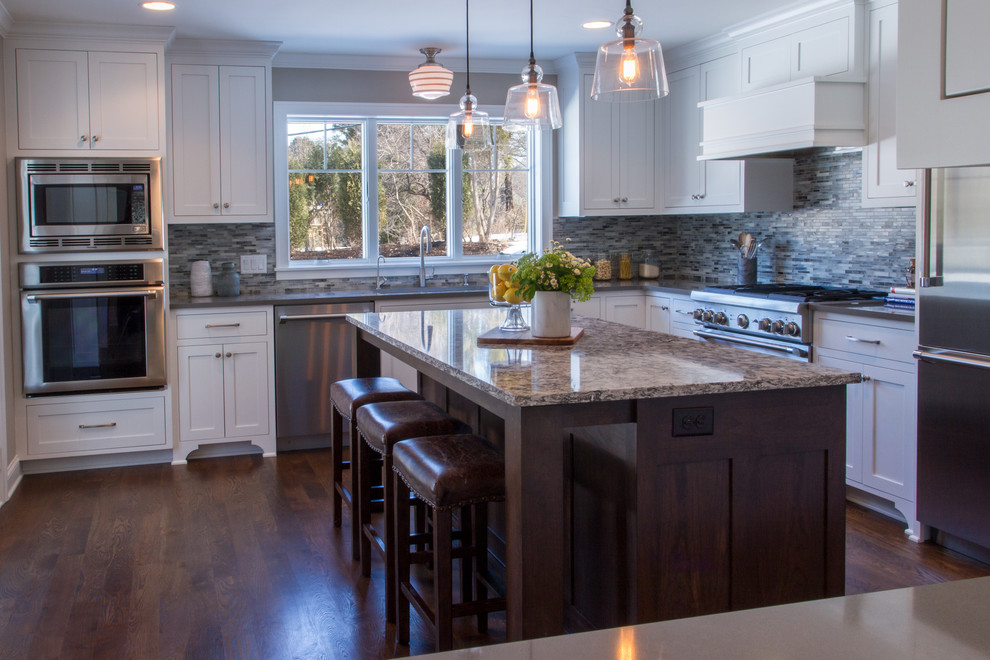 Eat-in kitchen - large traditional u-shaped dark wood floor eat-in kitchen idea in Minneapolis with a drop-in sink, glass-front cabinets, white cabinets, marble countertops, gray backsplash, mosaic tile backsplash, stainless steel appliances and an island