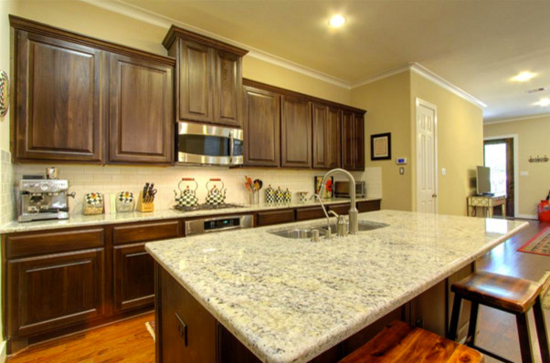 Example of an arts and crafts medium tone wood floor eat-in kitchen design in Houston with white backsplash, ceramic backsplash, an undermount sink and stainless steel appliances