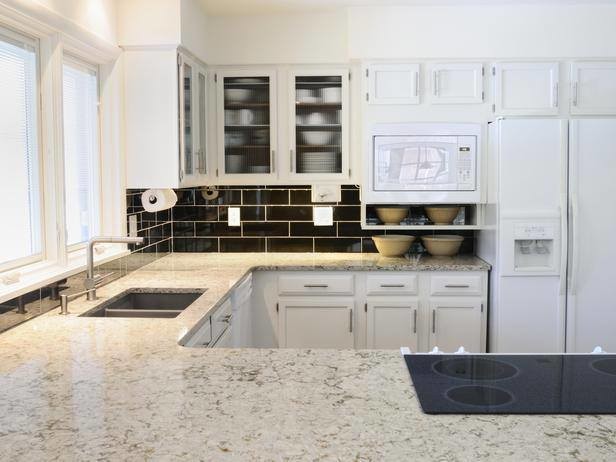 Design ideas for a medium sized u-shaped kitchen in Boston with a double-bowl sink, recessed-panel cabinets, white cabinets, granite worktops, black splashback, metro tiled splashback, stainless steel appliances and a breakfast bar.