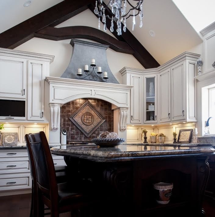 Klassisk inredning av ett stort kök, med en rustik diskho, luckor med upphöjd panel, vita skåp, brunt stänkskydd, rostfria vitvaror, mörkt trägolv, en köksö och brunt golv