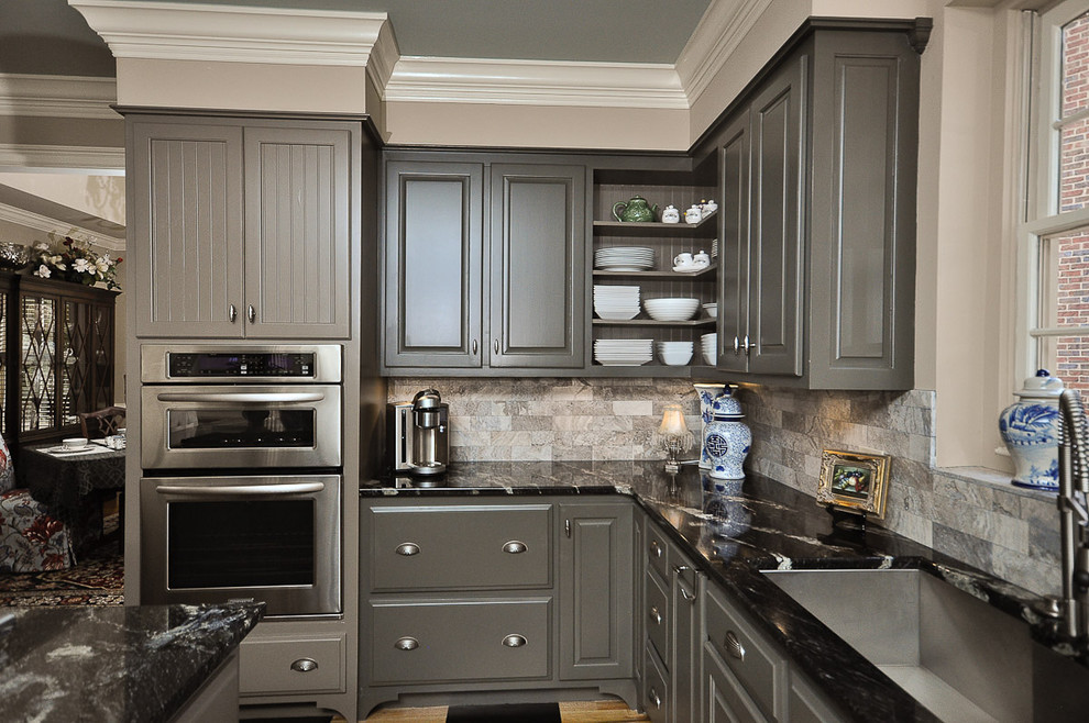 Photo of a medium sized traditional l-shaped kitchen in Other with raised-panel cabinets, grey cabinets, grey splashback, stainless steel appliances, granite worktops, painted wood flooring, an island, marble splashback and a submerged sink.