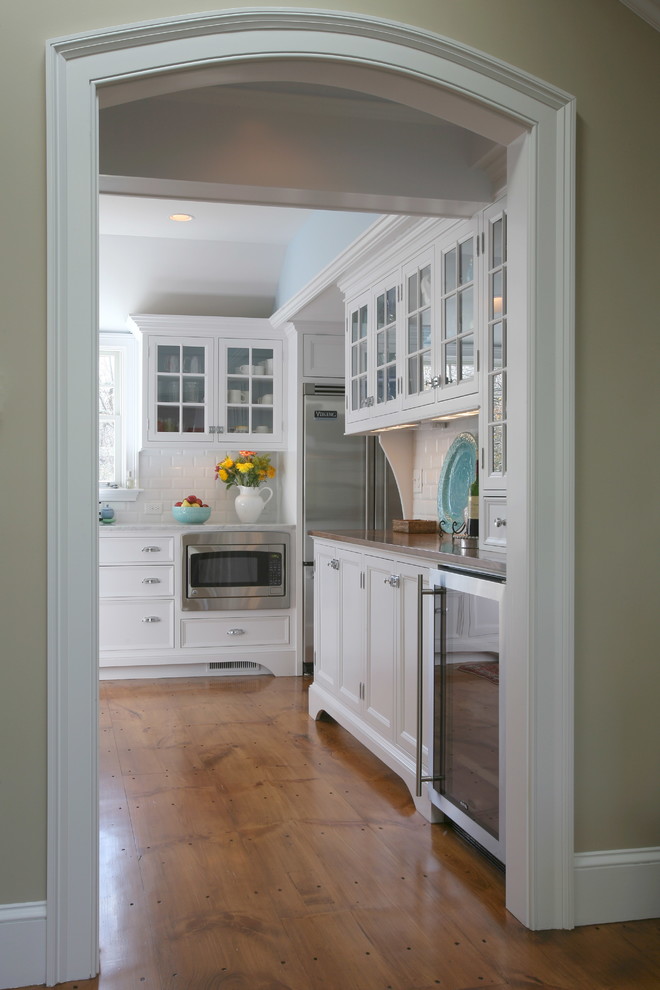 Immagine di una cucina classica di medie dimensioni con nessun'anta, ante bianche e pavimento in legno massello medio